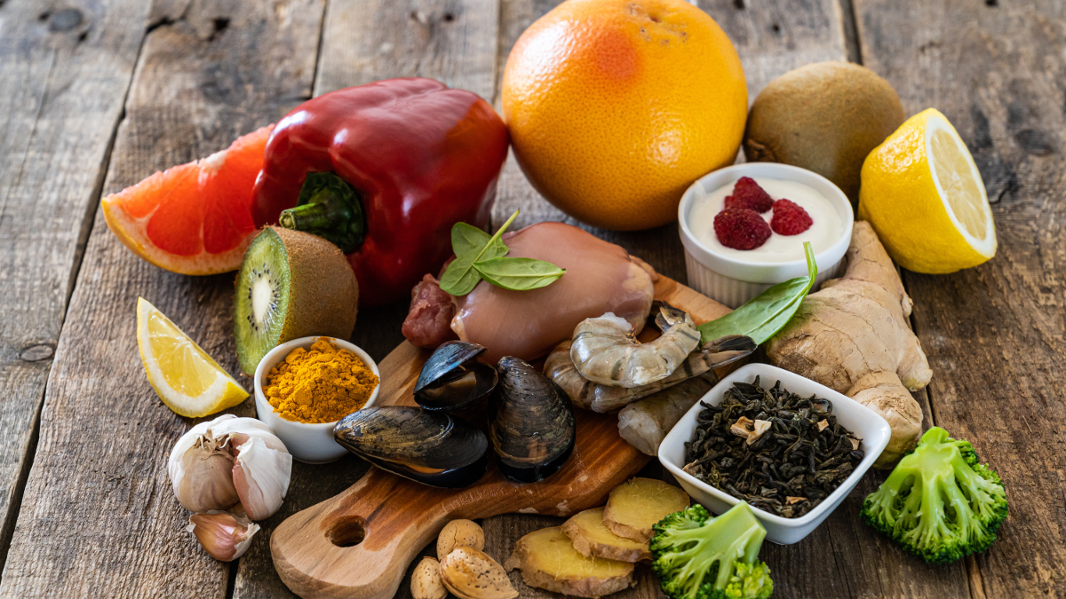 Oysters, garlic, pepper, yogurt, citrus fruit and other foods on a wooden table.