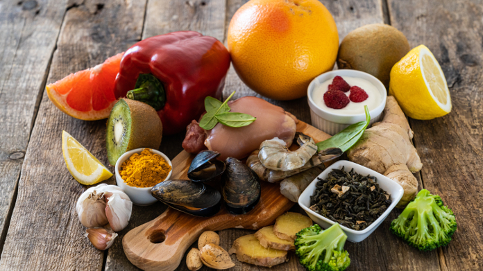 Oysters, garlic, pepper, yogurt, citrus fruit and other foods on a wooden table.