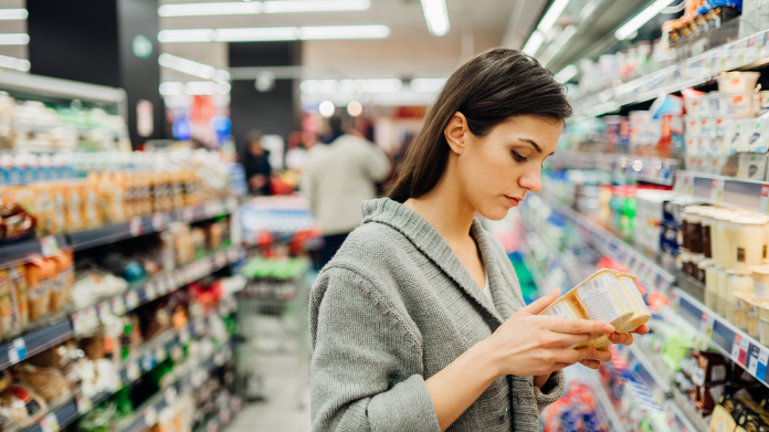 Donna anemica che controlla la composizione nutrizionale di un alimento in un negozio