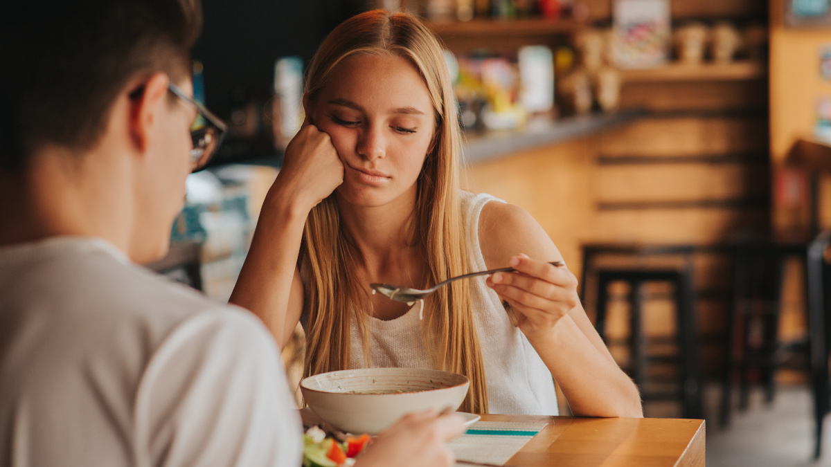 Vermoeide blonde vrouw tijdens eten