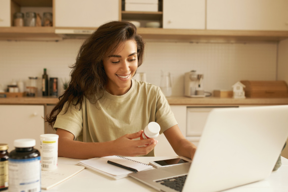 Jonge vrouw kiest een multivitaminesupplement