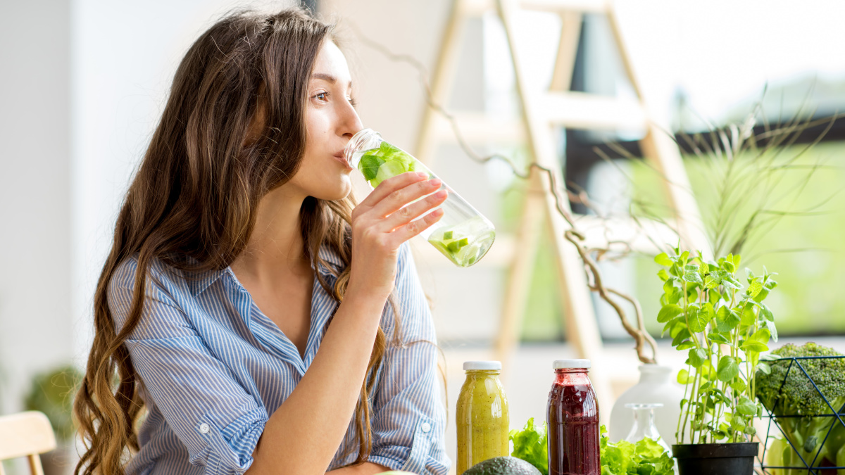 Mulher jovem a beber um sumo detox