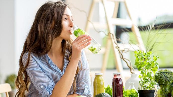 Jeune femme qui boit un jus détox